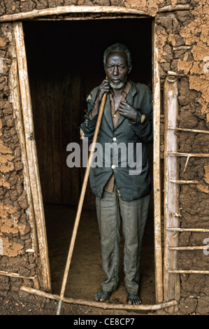 Donna anziana in piedi in ingresso a casa sua in Ruanda rurale, Africa Foto Stock