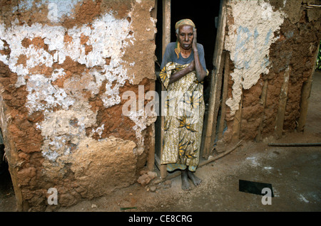 Donna anziana in piedi in ingresso a casa sua in Ruanda rurale, Africa Foto Stock