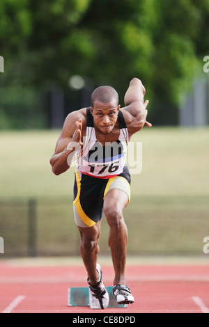 Atleta in volata dai blocchi di partenza Foto Stock