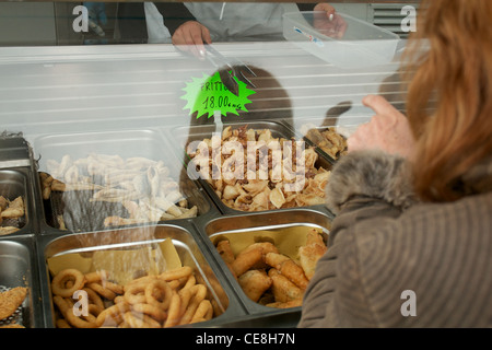 Una donna acquisti delicatezze Italiane e fritto misto da un venditore ambulante, Regione Marche, Italia Foto Stock