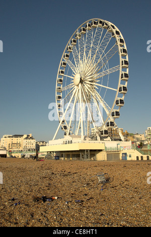 La ruota di Brighton attrazione turistica con rifiuti sinistra sulla spiaggia. Foto Stock