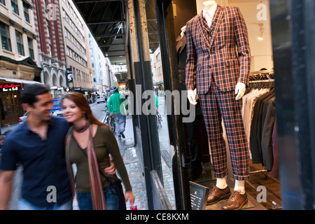 Giovane oltrepassando negozio di abbigliamento. La Flinders Lane, Melbourne, Victoria, Australia Foto Stock