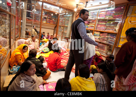 Negozio di vendita di sari di seta e tessuti, a famiglie indiane, in Johari Bazaar di Jaipur, nel Rajasthan, India. Foto Stock