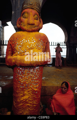 La superstizione monete bloccato sulla statua di demone indiano Malla un devoto del Signore Khandoba Jejuri maharashtra india Foto Stock