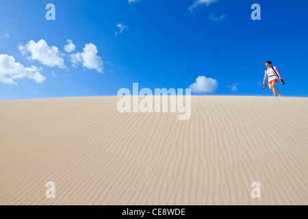 Donna escursionismo in dune di sabbia a Corralejo, Fuerteventura, Spagna Foto Stock