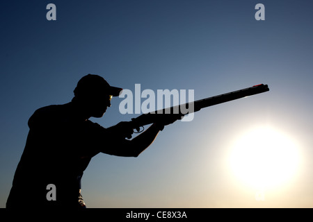 L'uomo preparazione per scattare con la sua pistola silhouette Foto Stock