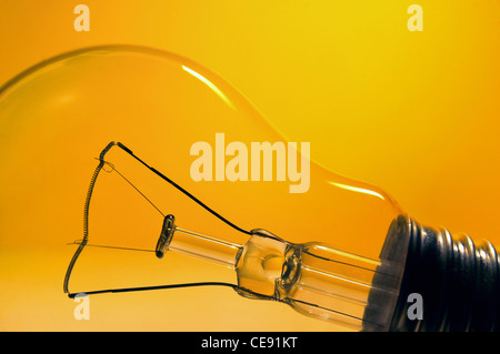 Fuori picco elettricità - Lampadina luce arancione su sfondo colorato Foto Stock