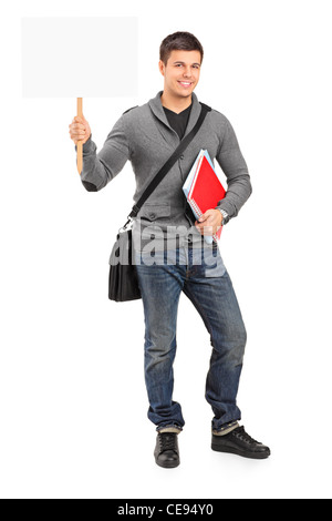 Sorridente giovane studente tenendo un vuoto bianco banner Foto Stock