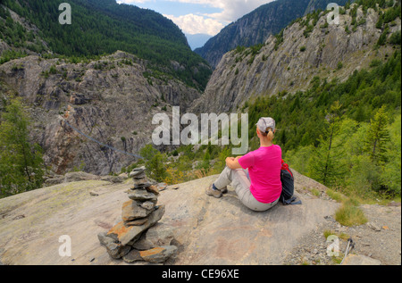 Montare la giovane donna gode di vista sulla valle di Aletsch con Belalp Riederalp Gruensee sospensione ponte verso il basso al di sotto, Svizzera Foto Stock