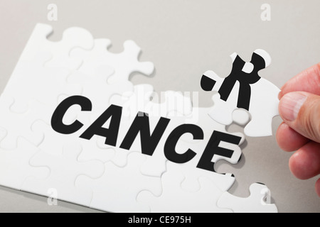 Maschio lato disponendo i pezzi del puzzle di precisare il cancro Foto Stock