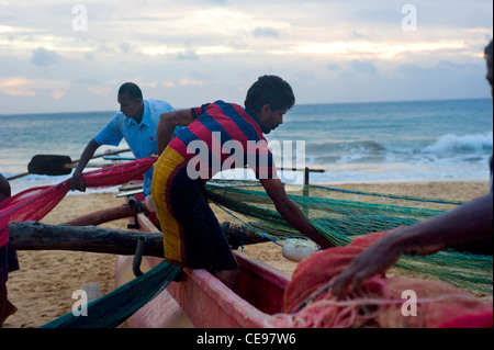 Gruppo di dello Sri Lanka pescatori pesca imballaggio net. La pesca in Sri Lanka è un lavoro duro, ma questo si guadagnano da vivere Foto Stock