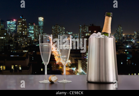 Stati Uniti d'America, Illinois, Metamora, Champagne flauti e la bottiglia nel secchiello del ghiaccio con skyline del centro in background Foto Stock