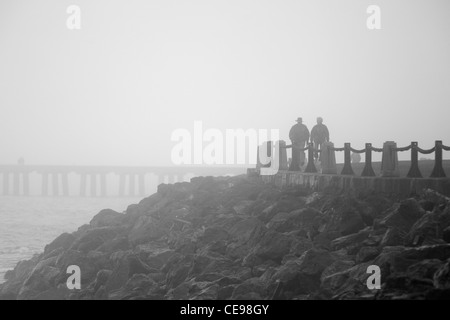 Una coppia di anziani a piedi nella fitta nebbia Foto Stock