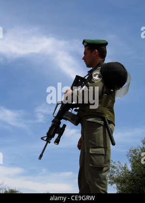 Un poliziotto di frontiera armato d'Israele è in piedi guardia a Gerusalemme est d'Israele Foto Stock