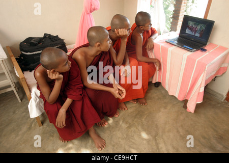 Un gruppo di giovani monaci buddisti guardare una presentazione di fotografie scattate dal fotografo Ben Wyeth su un latop Foto Stock