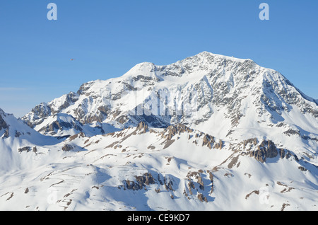 Coperta di neve montagna, cielo blu, rosso distanti elicottero, Tignes della Vanoise, Alpi,Savoire, Francia,l'Europa Foto Stock