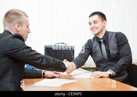 Giovane uomo d affari si stringono la mano con il collega attraverso il tavolo Foto Stock