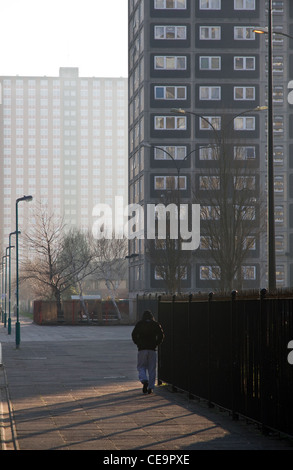 Giovane uomo a piedi attraverso Pendleton alloggiamento station wagon, centrale Salford, Greater Manchester, Inghilterra, Regno Unito Foto Stock