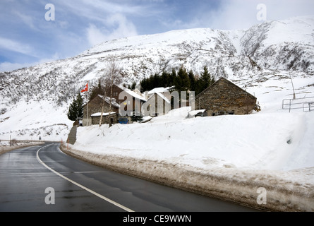 Una casa colonica, completa con una battenti bandiera svizzera, adiacente alla strada di un paese in Svizzera Foto Stock