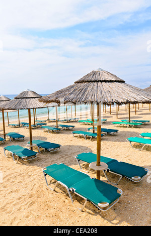 Ombrelloni di paglia sul vuoto seaside beach in Grecia Foto Stock