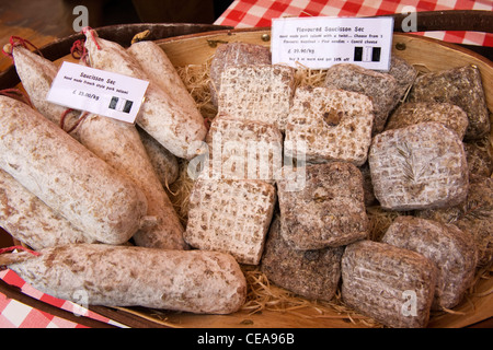 Borough Market London salumi salsicce salsiccia francese sec salame di maiale aromatizzato nocciola aghi di pino comte formaggio ciotola di legno Foto Stock