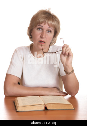 La donna matura con libro dietro un tavolo su sfondo bianco Foto Stock