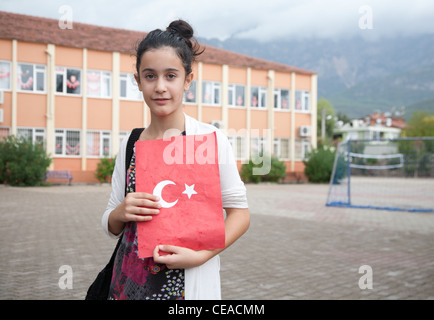 Bagno turco schoolgirl celebra la Repubblica turca giorno nella città di Tekirova, azienda artigianale di cartella con simboli nazionali Foto Stock