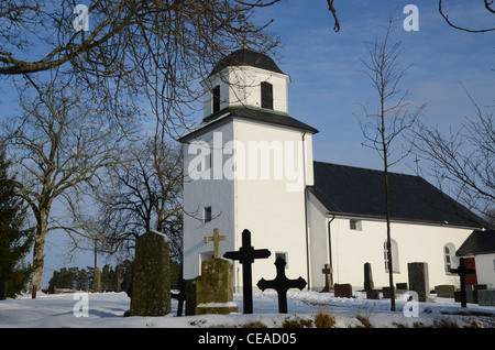 Chiesa bianca e lapidi in inverno Foto Stock