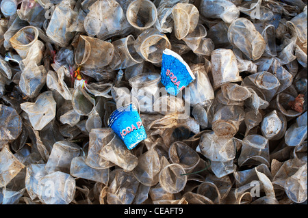 Carta scartata soda tazze di plastica tra tazze tè nella campagna indiana. Andhra Pradesh, India Foto Stock