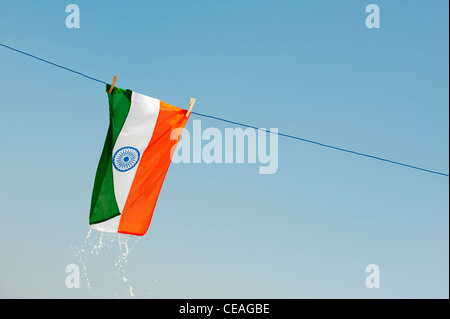 Wet gocciolamento bandiera indiana su una linea di lavaggio contro un cielo blu. Andhra Pradesh, India Foto Stock