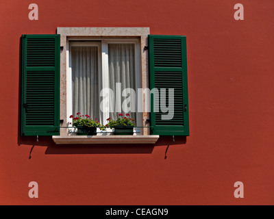 Finestra, persiane e parete in italiano colori del rosso, del verde e del bianco. Foto Stock