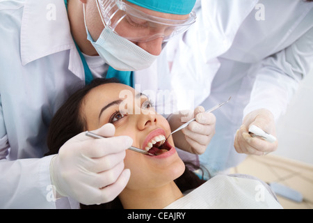 Dentista e il suo assistente di effettuare un esame approfondito Foto Stock