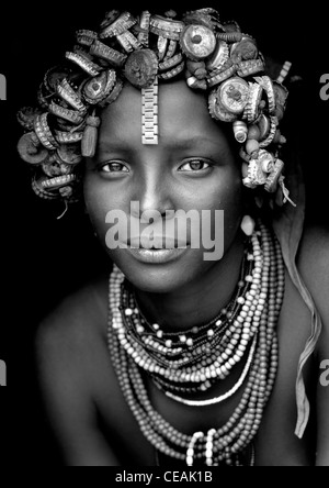 Ritratto di un giovane Dassanech carino donna che indossa i tappi di bottiglia copricapi e collane di perle Valle dell'Omo Etiopia Foto Stock
