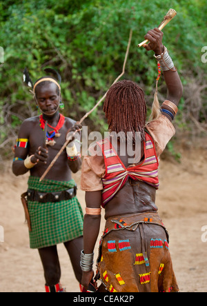 Whipper davanti alla donna Hamer egli è circa a flog celebrando Bull Jumping cerimonia Etiopia Foto Stock