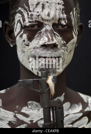 Karo faccia dipinta con vernice bianca e Kalashnikov canna di fucile ritratto Etiopia Foto Stock