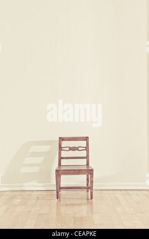 Sedia vuota in una stanza vuota Foto Stock
