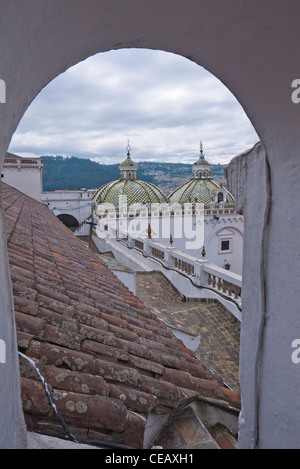 Vista dei due cupole de La Compañía de Jesús chiesa attraverso un tetto alto portale ad arco a Quito, Ecuador. Foto Stock
