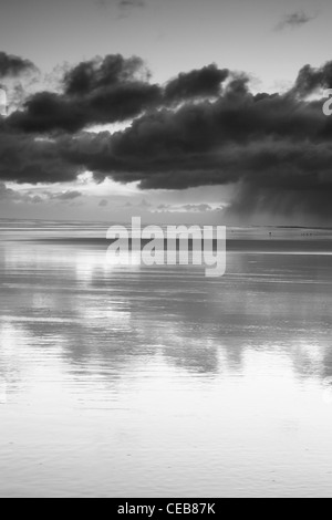 Soleggiato nuvole riflettono nella sabbia bagnata sulla spiaggia Bamburgh. Foto Stock