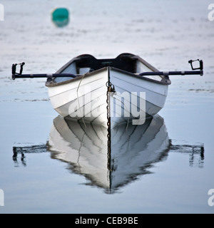 In legno bianco o scull riga barca poggia pacificamente in acqua Foto Stock