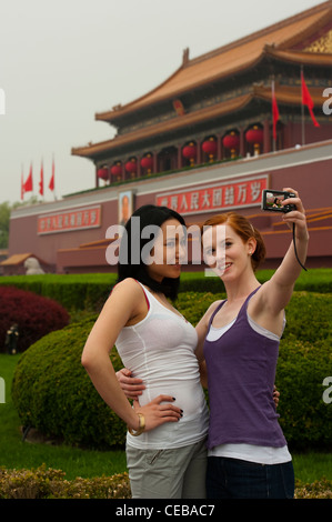 I turisti tenendo la propria fotografia nella parte anteriore della porta della pace celeste, la Città Proibita di Pechino, Cina, Asia. Signor Foto Stock