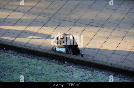 Una verso il basso e fuori seduta su una cassetta da frutta Inghilterra Regno Unito Foto Stock