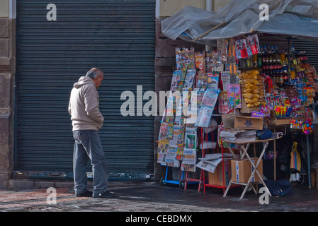 Un 50-60 anno vecchio guarda la rivista la visualizzazione in un edicola in Quito, Ecuador. Foto Stock