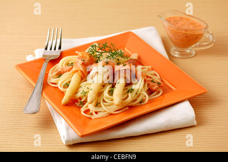 Gli spaghetti e asparagi con pesci affumicati. Ricetta disponibile Foto Stock