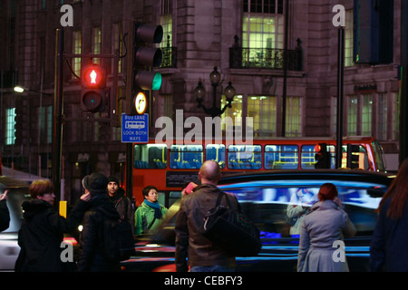 Le persone in attesa di attraversare una strada in corrispondenza di un attraversamento pedonale a Londra Foto Stock