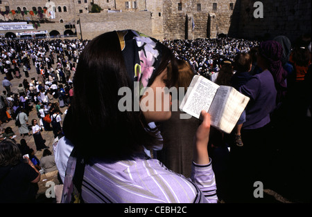 Una giovane ebrea religiosa che legge il libro di preghiera di Sidur nel Muro Occidentale o Kotel nella città vecchia di Gerusalemme Est Israele Foto Stock