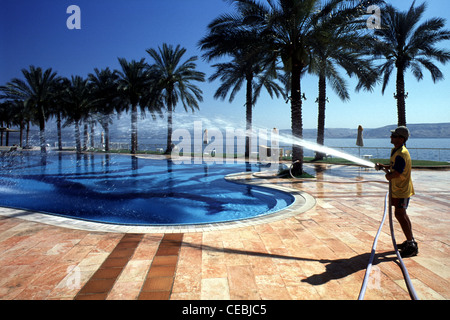 Un lavoratore la pulizia di una piscina in un parco a tema a Tiberiade presso la riva occidentale del Mare di Galilea, anche Kinneret o del lago di Tiberiade un grande lago di acqua dolce nel nord di Israele Foto Stock