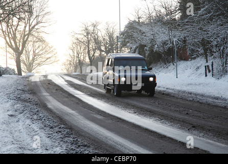 Un 4x4 la guida su una coperta di neve strada in U.K. Foto Stock