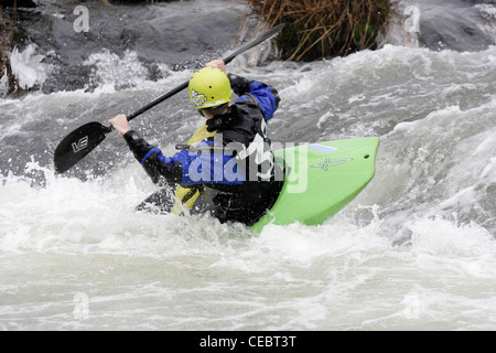 Uomo maschio canoeist prendendo parte a inter universitaria concorrenza sul fiume Exe Exeter 4/2/12 riprese su uno stramazzo Foto Stock