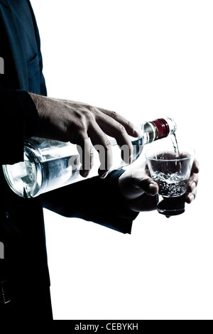 Un uomo caucasico le mani vicino la colata di alcool bianco in una silhouette di vetro in studio isolato sfondo bianco Foto Stock