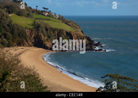 Giovane camminando lungo Blackpool Sands Beach, Sud prosciutti, South Devon, in Inghilterra. Foto Stock